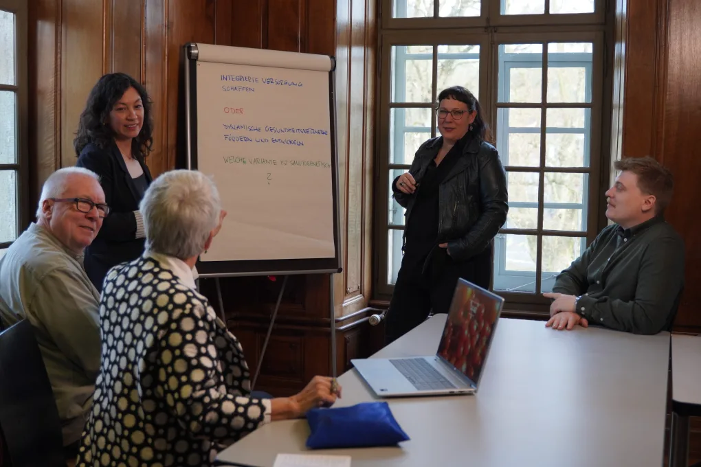 Strategieworkshop von vitalba: fünf Personen erarbeiten am Flipchart Ziele für die integrierte Versorgung.